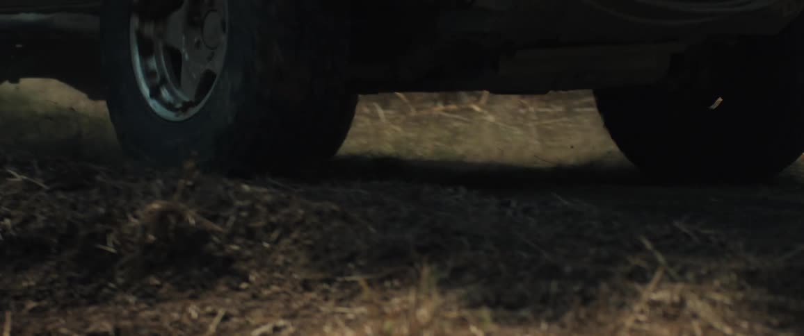 Front of suv with winch moves along a dirt trail in a forest area
