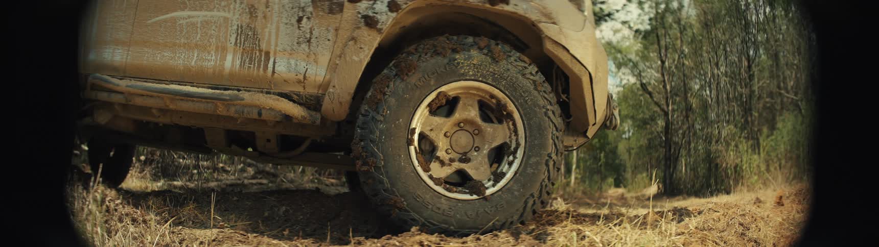 Rear tire of offroad vehicle covered in mud