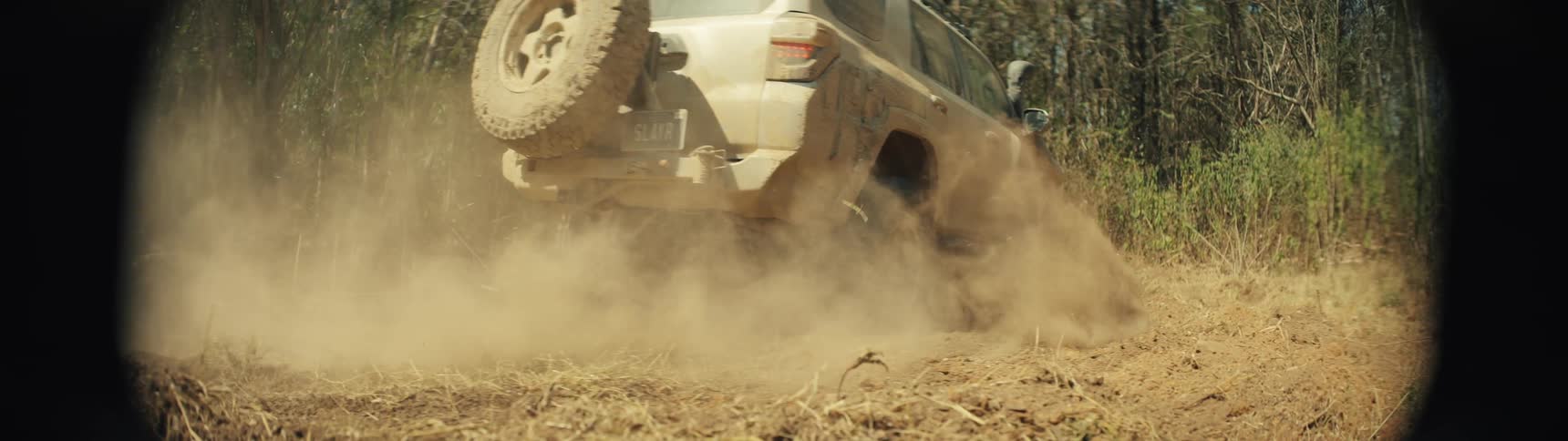 Offroad vehicle in motion raising dust