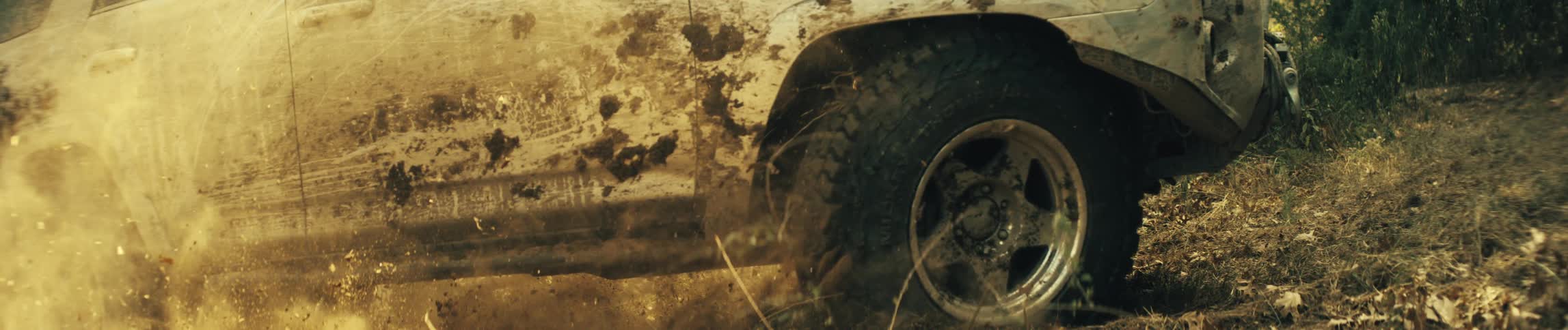 Suv wheels move over uneven ground with dirt and dry leaves
