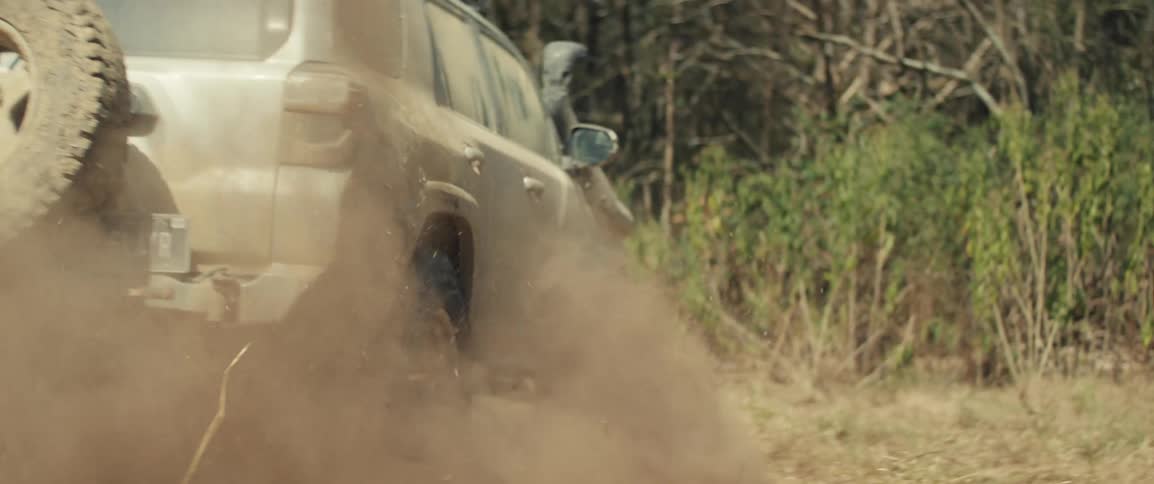 Offroad suv kicking up dust on dry terrain
