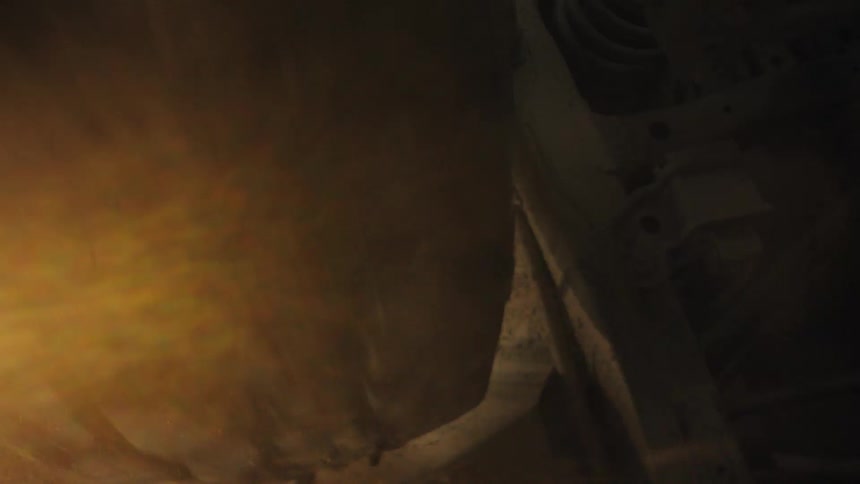 A car tire spinning fast covered in mud spraying dust while suspended in midair