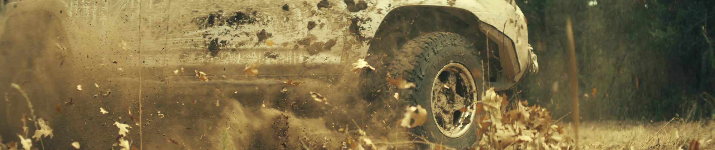 Offroad vehicle speeding and kicking up dry leaves
