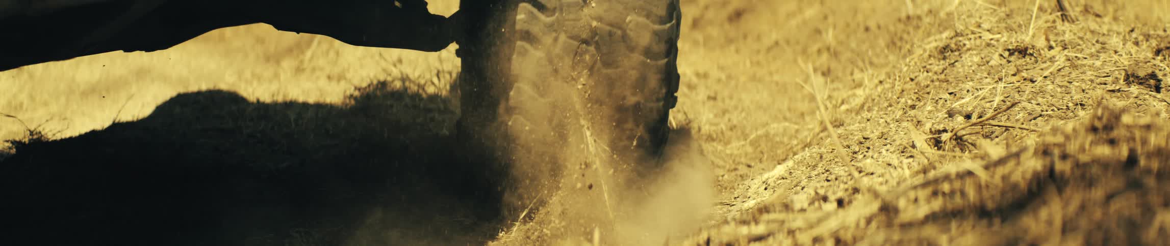 The tires slowly turn in the dirt