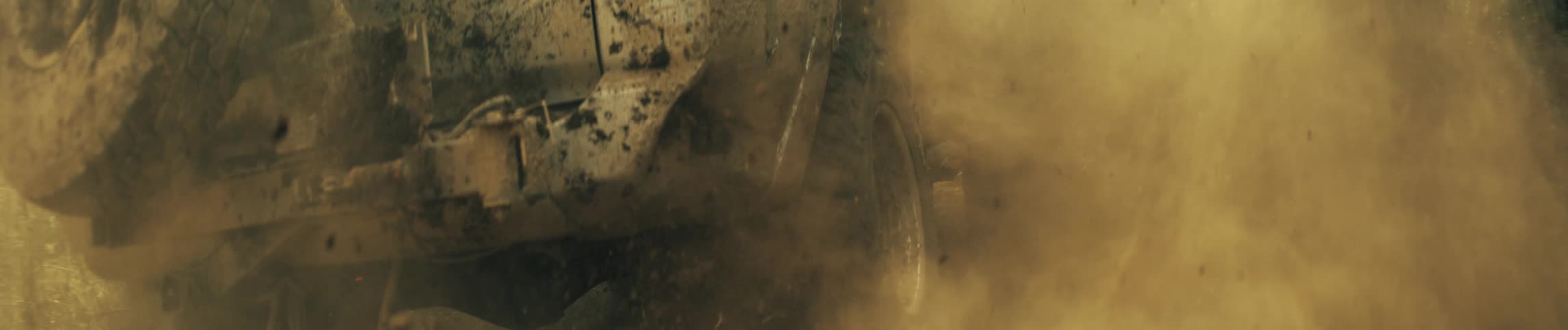 Suv wheel spins rapidly on a dirt road raising a large cloud of dust