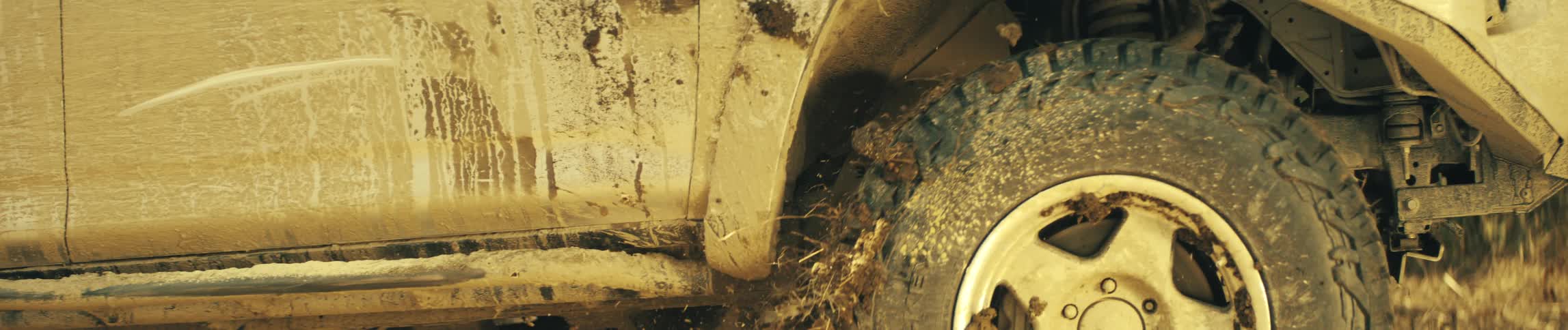 A vehicle driving outdoors in the dirt