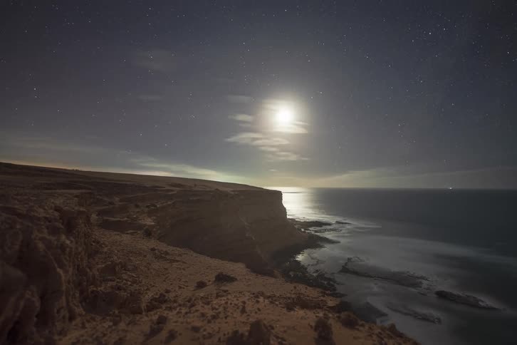 A time lapse of the sun setting over a coast