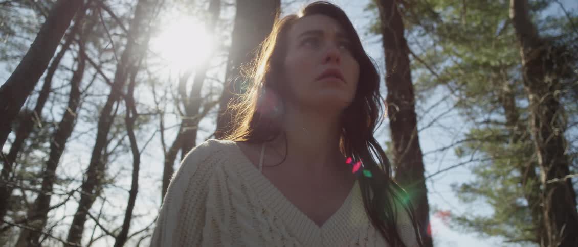 Woman looks around the forest distraught