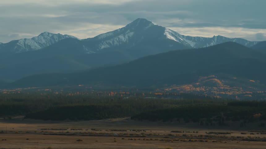 A landscape with some snow capped mountains in the distance