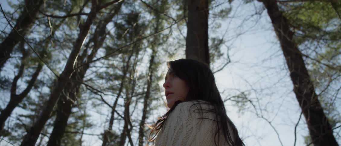 A woman is walking in the woods