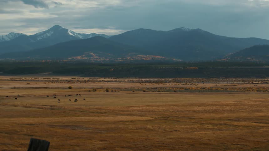 The first is the jagged dark blue mountain range in the background which separates the cloudy sky from the valley floorthe second is the flatter line of the horizon where the goldenbrown fields meet the base of the foothills and distant trees