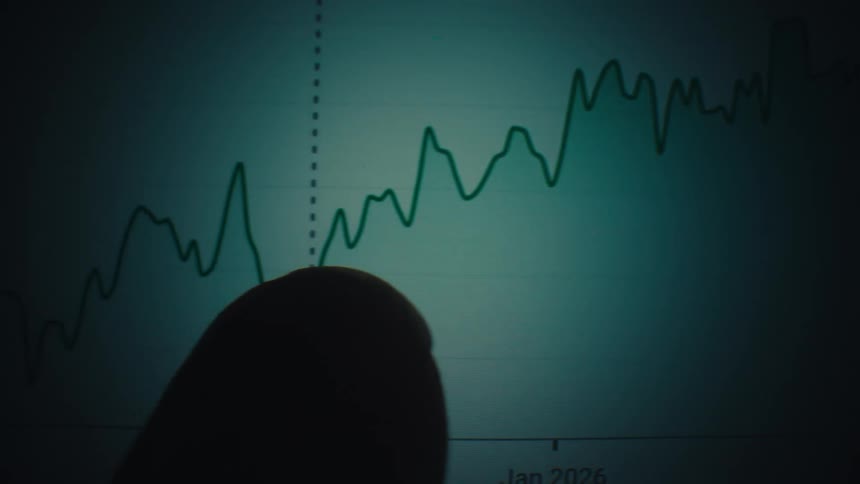 Finger points to a point on a line chart showing value fluctuations