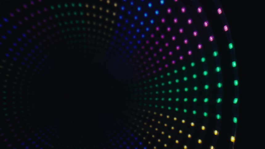 Outline of a tube of glowing orbs of colored lights in the darkness