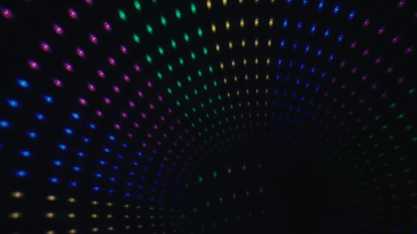 Glowing led dots create a colorful tunnel disappearing into a dark void