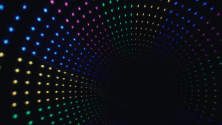 Glowing orbs of colored lights move across the darkness in a circular formation