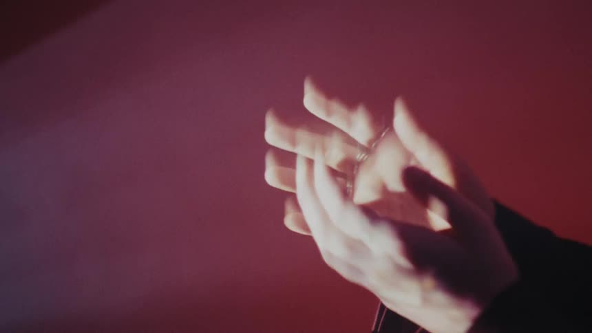 The woman waves her hands over the strobe lights
