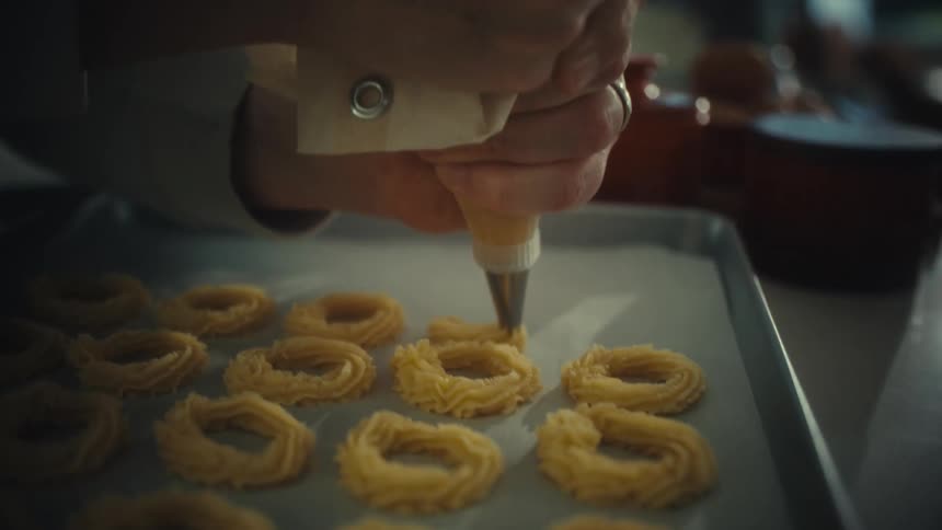 The man is making circle pastries in the kitchen