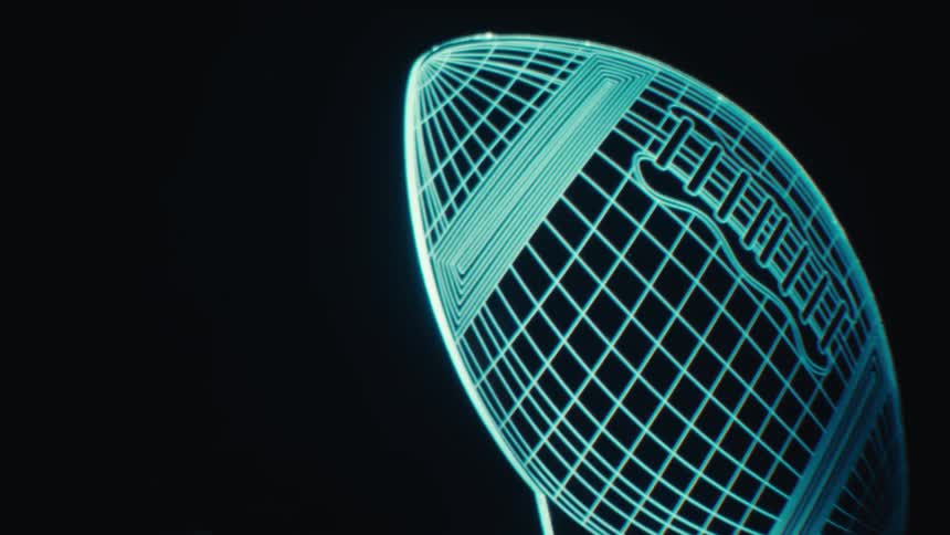 A glowing neon wireframe football rotates on a stand in a dark futuristic setting