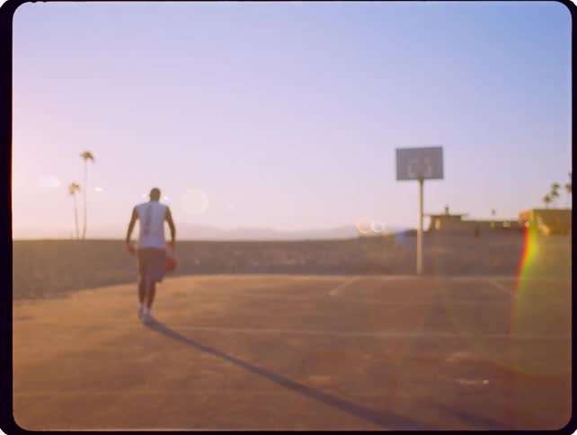 The man dribbles the basketball towards the hoop