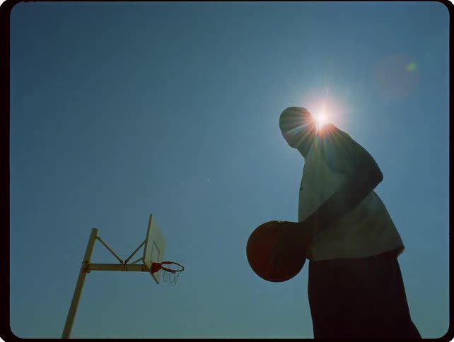 A man standing outdoors with a basketball