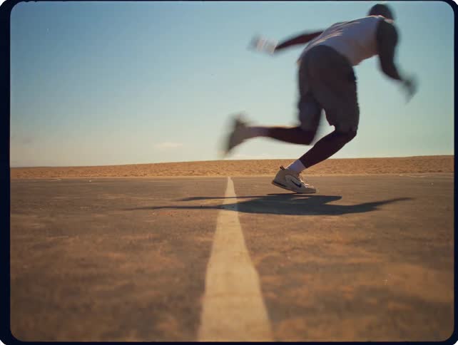 Man runs and touches road with center line under clear sky