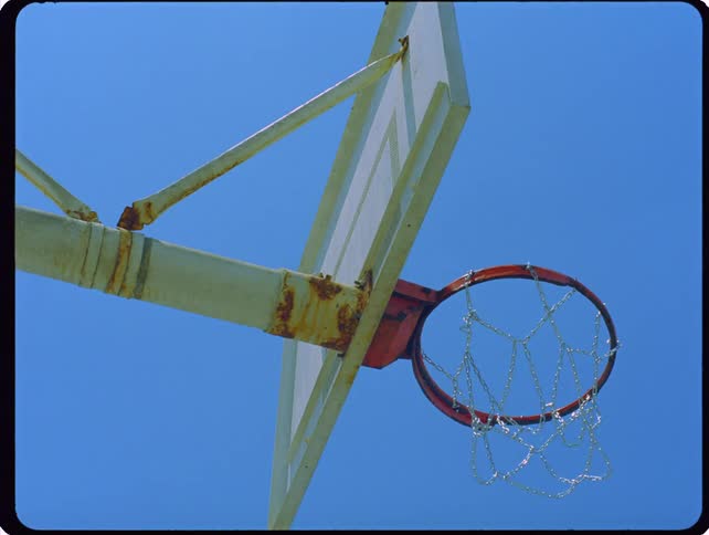 A basketball going into a hoop outdoors