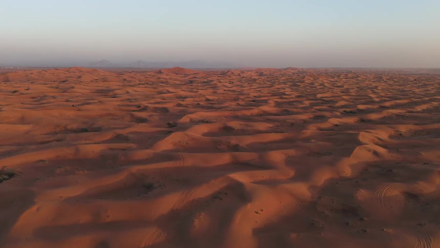 Shadows fill the area between dunes in the desert during the daytime