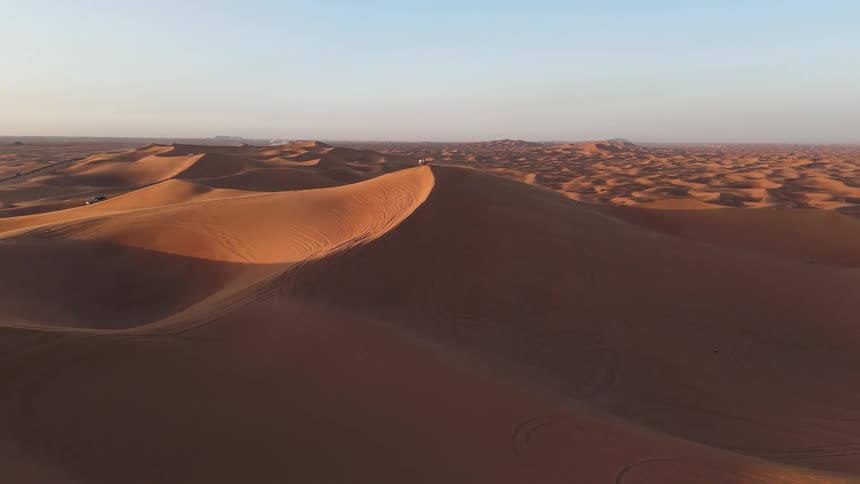 An aerial view of a sand dune on a sunny day