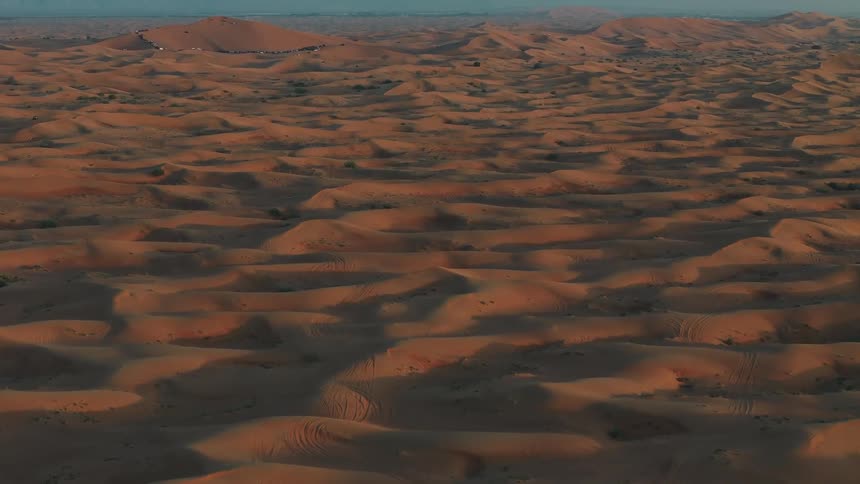 Extensive landscape of sand dunes forms a wavy terrain in the desert