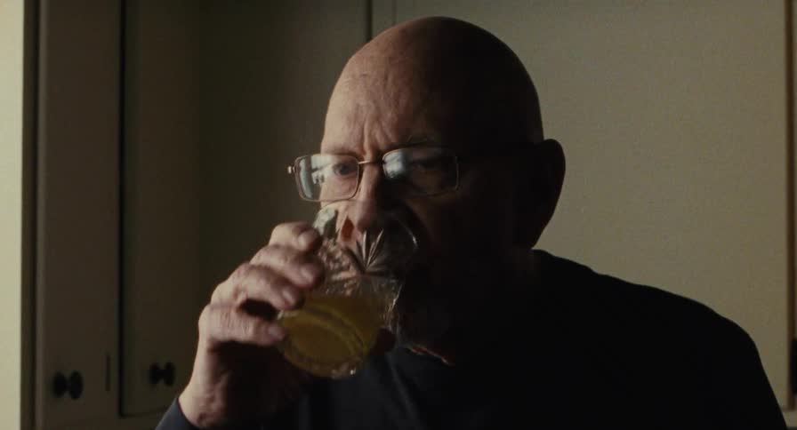 Man picks up a glass and takes a drink