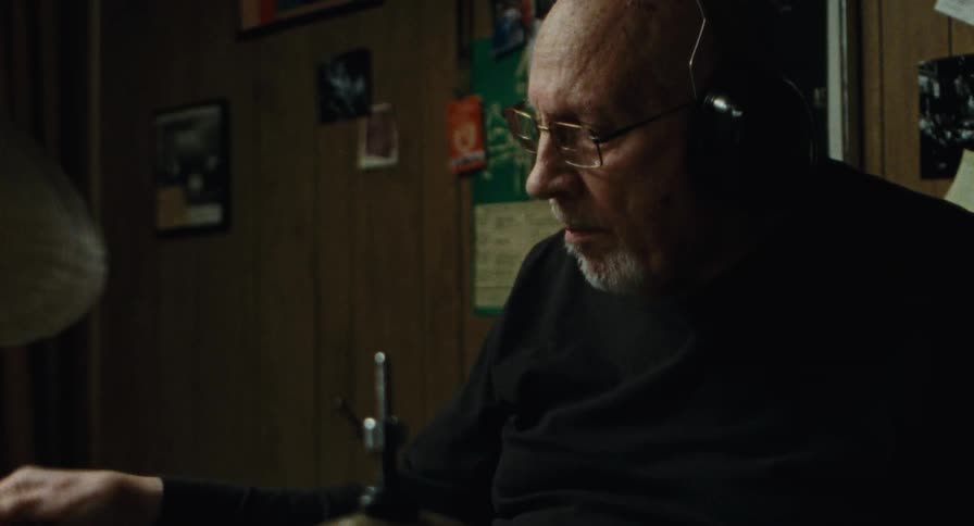 An old man plays the drums