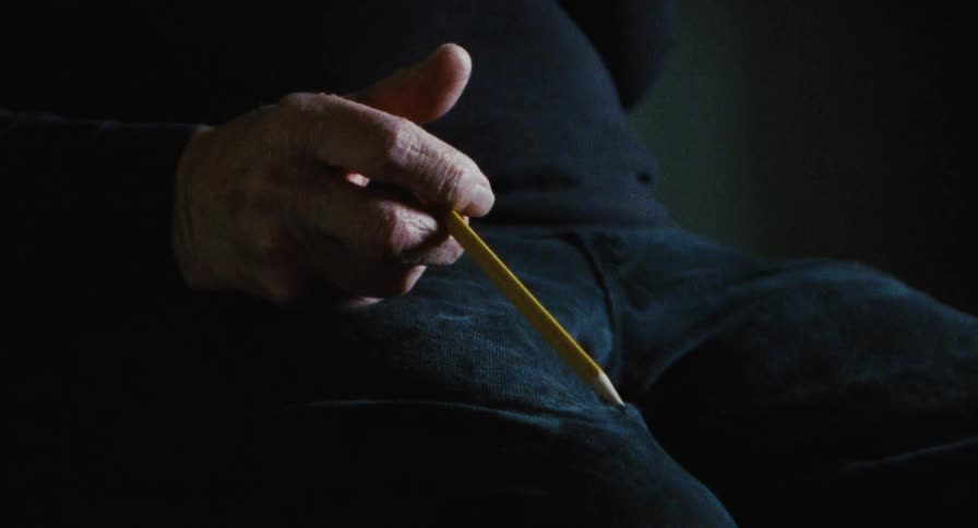 A man tapping a pencil on his leg