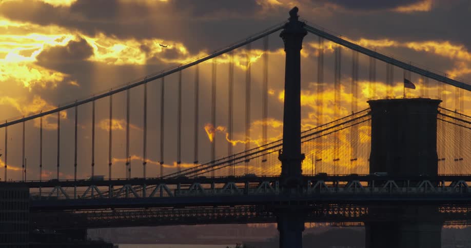Cars travel over a bridge at dawn