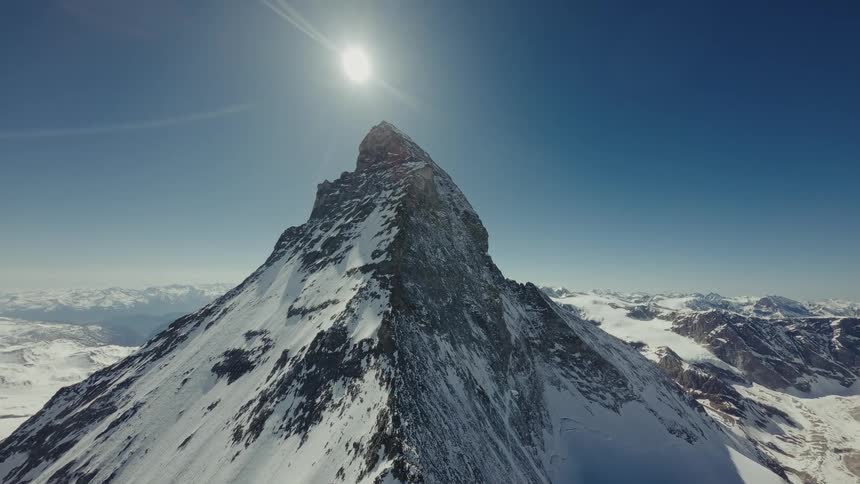 Snowcovered mountain peak illuminated by the sun in a blue sky