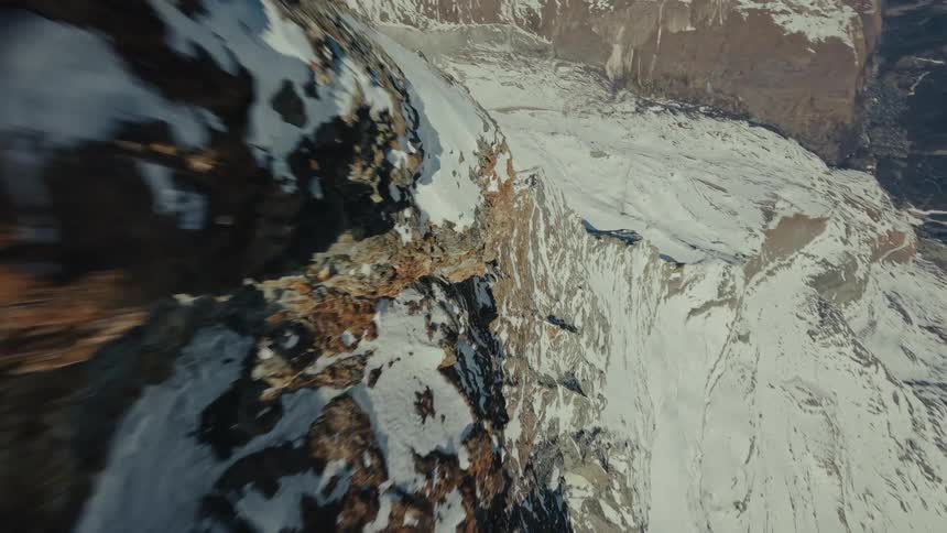 Mountain ridge with rough rocky terrain and snow cover on the slopes