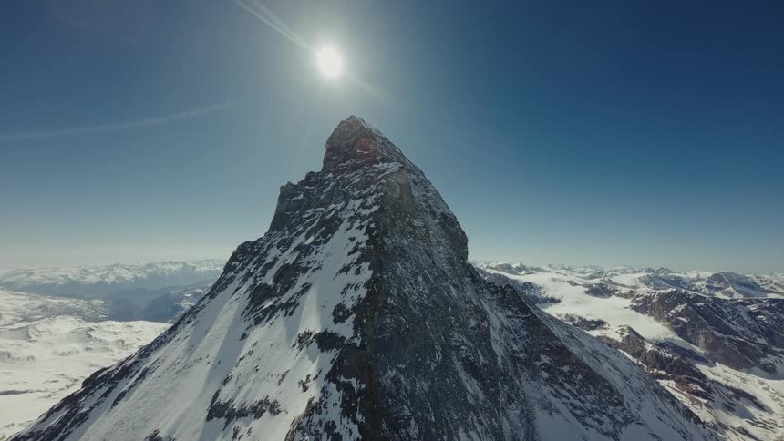 Snowcovered mountain peak under the sun in a blue sky