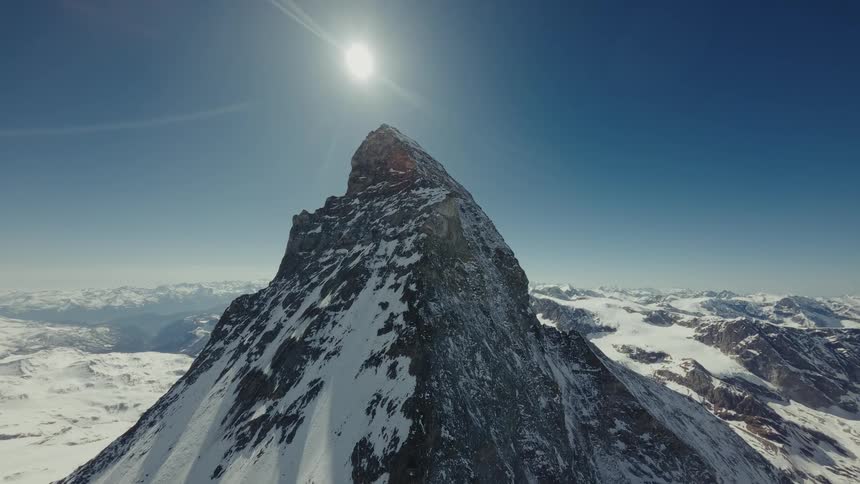 A mountain in the arctic covered in snow on a sunny day