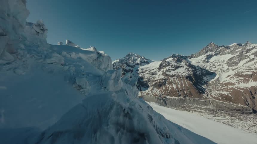 Ice formations and snowcovered mountains under a blue sky