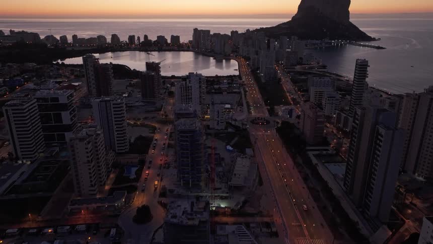 Coastal city with tall buildings and central illuminated road