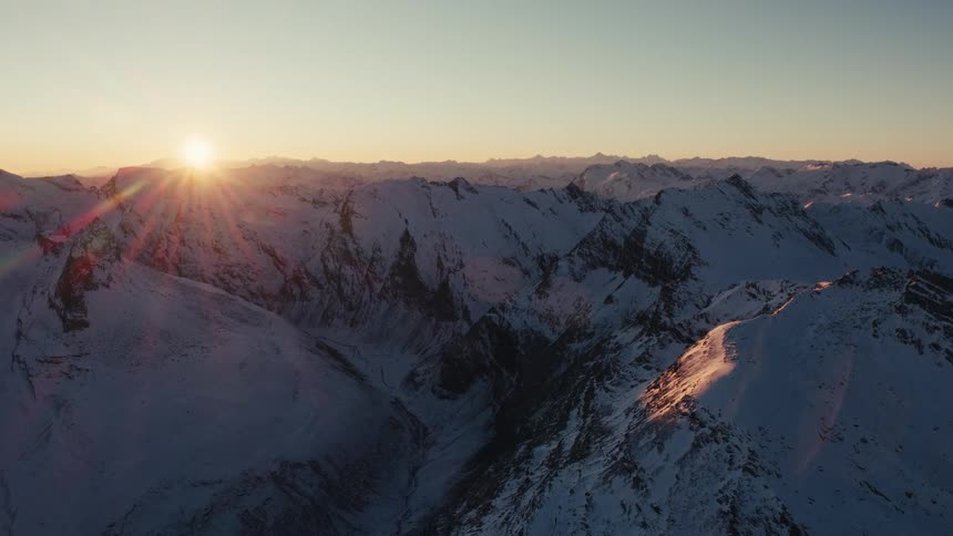 An aerial view of a mountain range covered in snow
