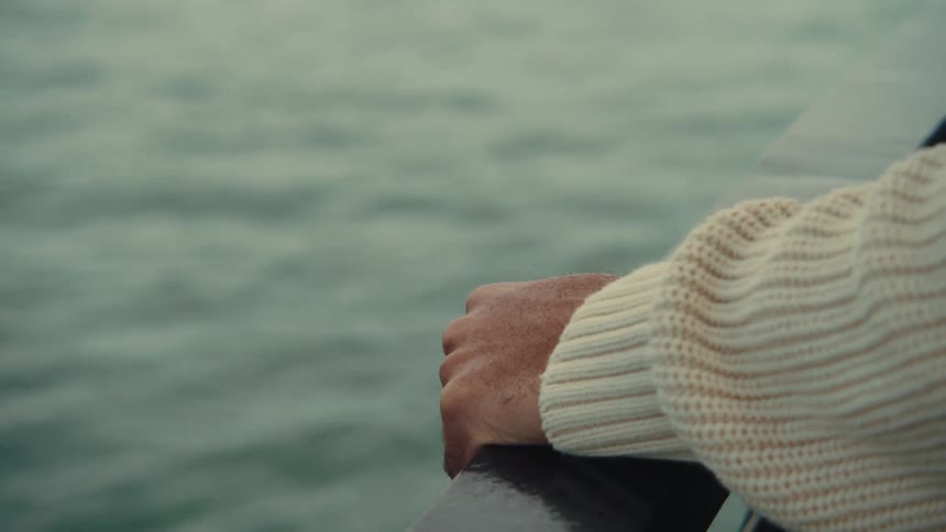 Man smiles with the sea in the background