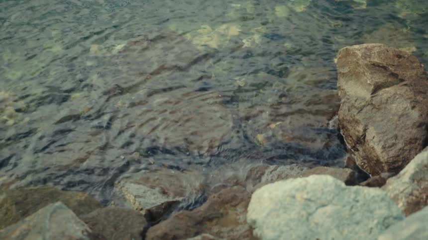 Clear water splashes against rocks along the coast