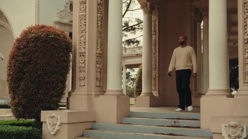 Man photographing with a camera on the steps of a building with ornate columns