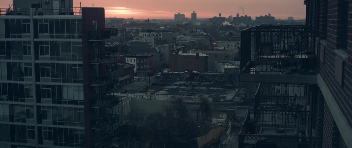 View of a town with a bus driving down a street at dusk