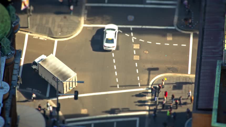 Some cars driving around in a city