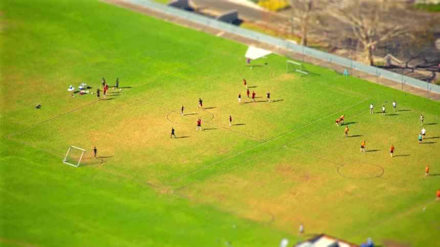 A group of people playing soccer outdoors
