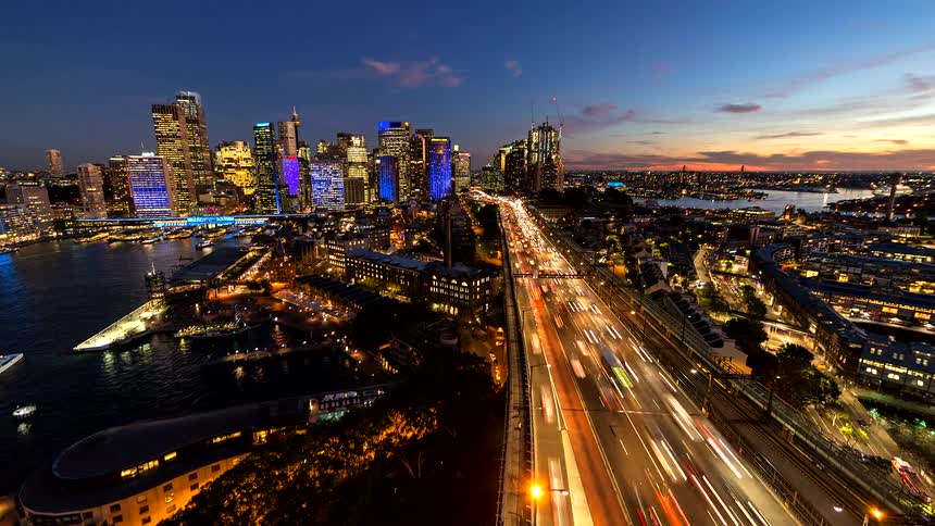 This is a glowing multilane artery of light cutting through the right side of the frame longexposure photography transforms the moving vehicles into continuous white and red streaks creating a sense of rapid motion and connectivity leading toward the