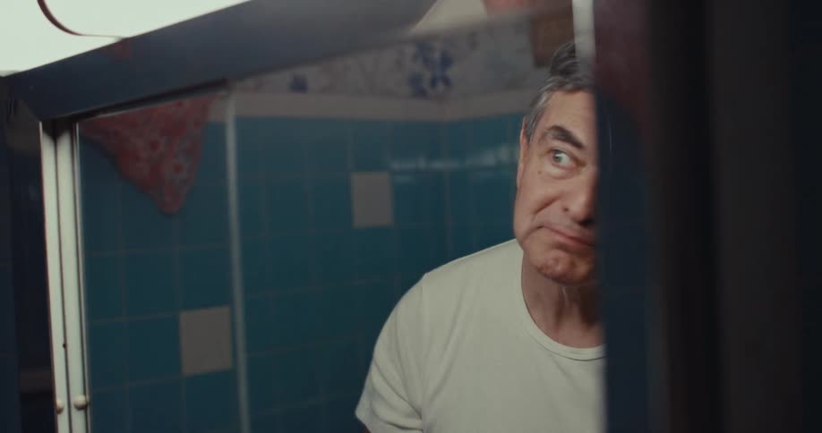 A man fixing his hair in a mirror