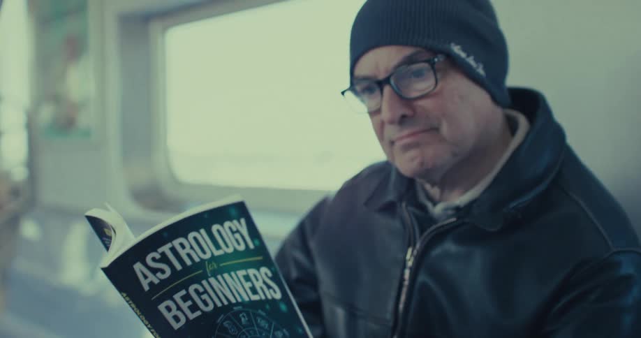 The man reads an astrology book on the train