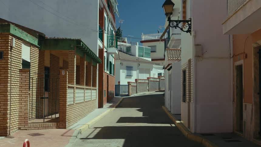 Narrow street with white houses and brick facades under a blue sky